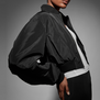 Model wears NAOMI In Fashion cropped bomber jacket by BOSS - side view